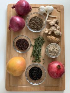 Herbs and spices for fire cider on a bamboo cutting board